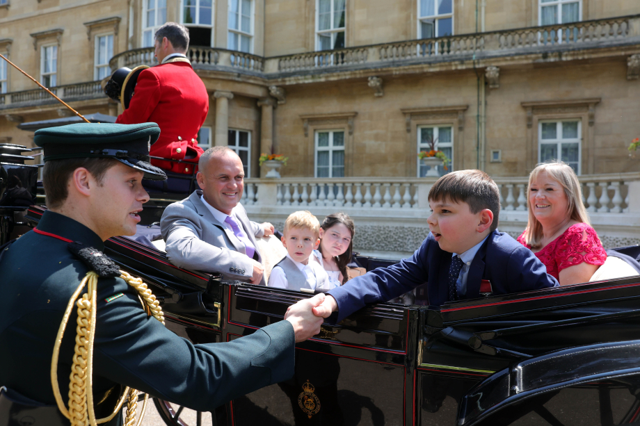 Tony shakes hands with The Queen's Equerry in a horse drawn carriage with Lyla and their families